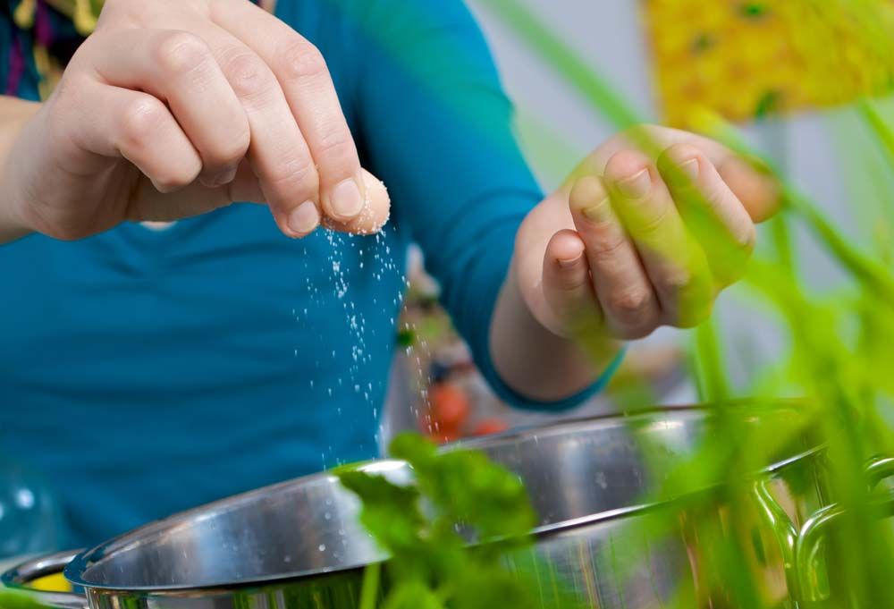 Koch salzt Suppe für ein Catering
