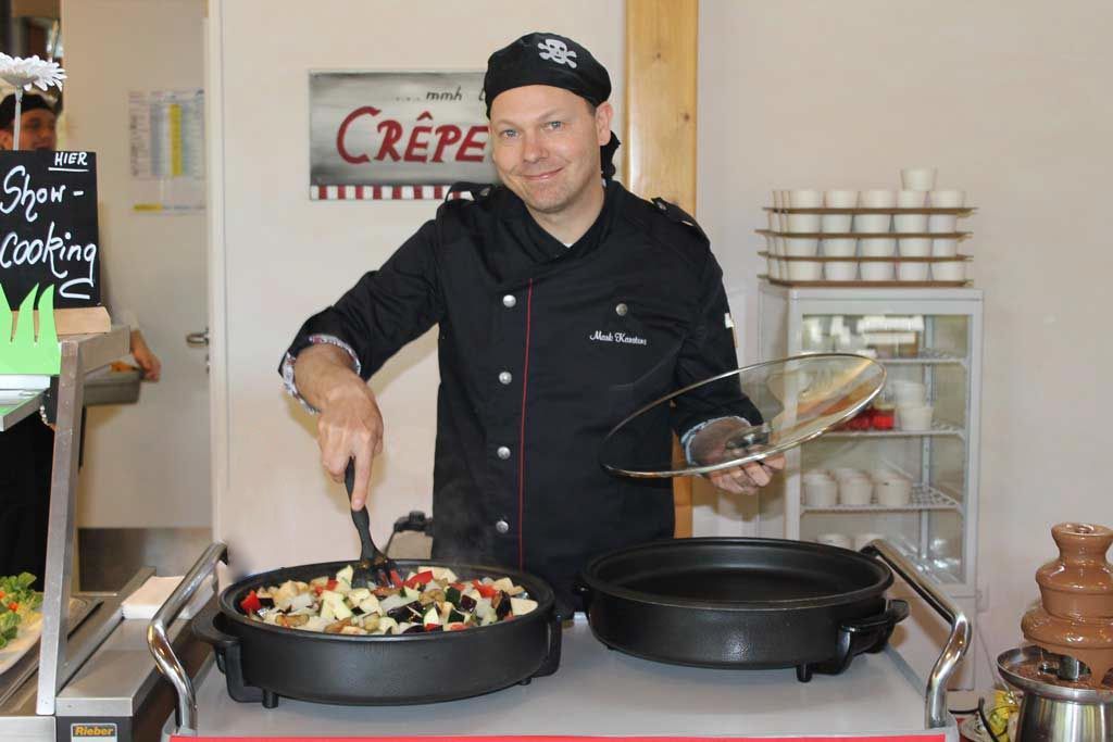 Koch Mark Karstens rührt in einer Pfanne für ein Catering in Kaltenkirchen